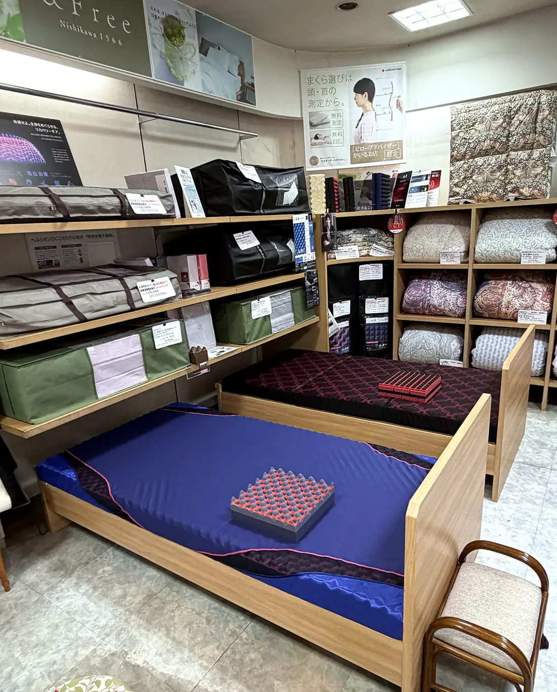 おおつき堂の店内。手前と奥に体験ベッド、壁の棚にマットレスや羽毛ふとんが並ぶ